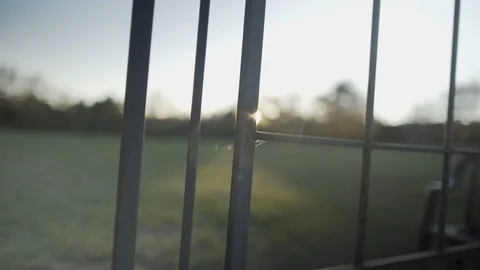 Sun peaking through fence at magic hour Stock Footage 91468386
