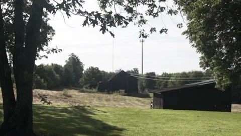 Sun Peaking through Tree with Country Barn in Slow Motion Stock-Footage 231240254