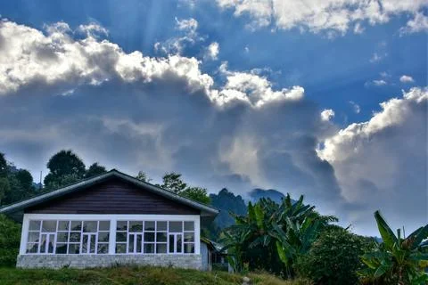 Sun peeking out from behind the cloud, with blue sky Stock Photos