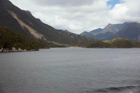 Sun peeking through the clouds at Doubtful Sound. Stock Photos