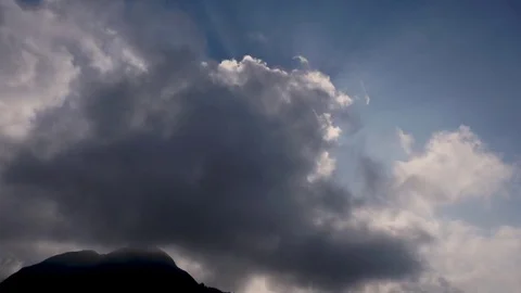 The sun peeking through the clouds. Shining sun rays breaking through cloud mass Stock Footage 83797649