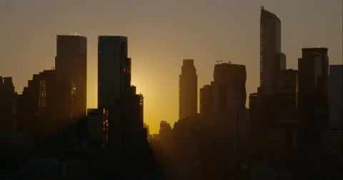 The sun peeks out from behind the Manhattan Skyline early morning. Stock Footage 62350069