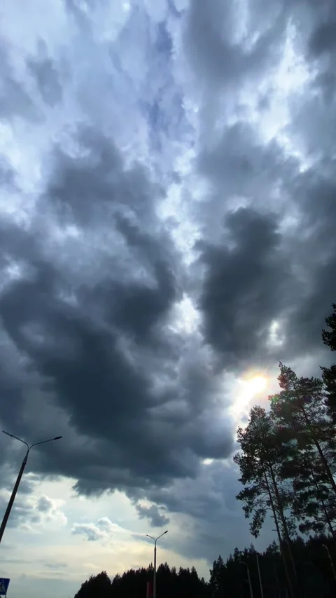 The sun peeks out from under the clouds. Vertical video Stock Footage 276179885