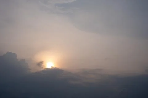 Sun peeks through clouds at dusk Stock Photos