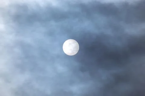 Sun peeks through clouds in the sky during a cloudy day Stock Photos