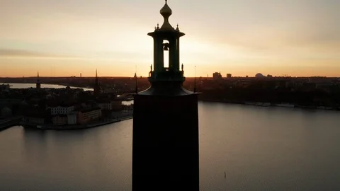 Sun peeks through famous City Hall in Stockholm during sunrise, aerial view. Stock Footage 122320010