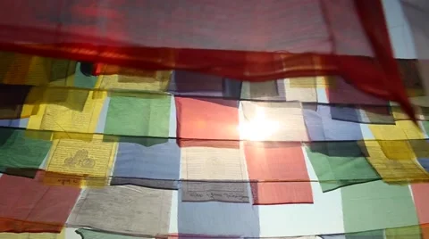 Sun peeping behind prayer flags Stock Footage