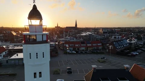 Sun piercing behind lighthouse in near static dawn frame Stock Footage 331841886