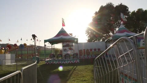 Sun preparing to set over empty carnival Stock Footage 154569377