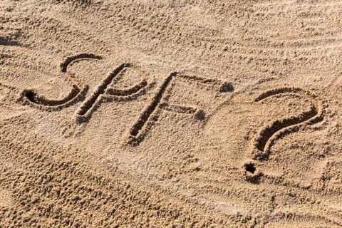 Sun protect factor concept. SPF word written on the beach with question mark Stock Photos
