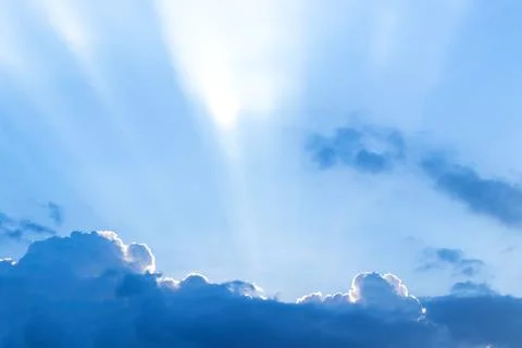 The sun ray behind the clouds in the blue sky. Stock Photos