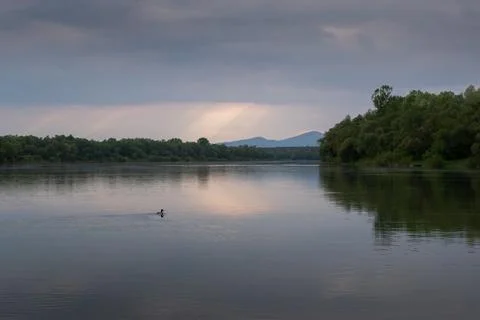 Sun ray piercing through clouds over river Stock Photos