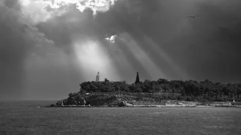 Sun rays after storm over lighthouse.Greece	 Stock Photos