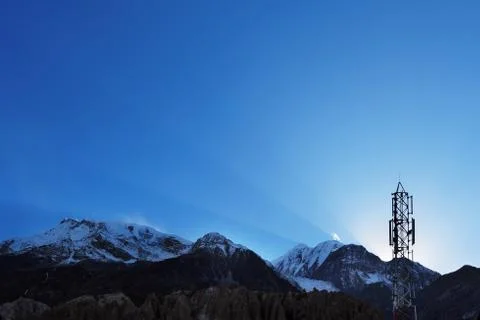 Sun rays and cellular transmitter in the sky over the Himalayas Stock Photos
