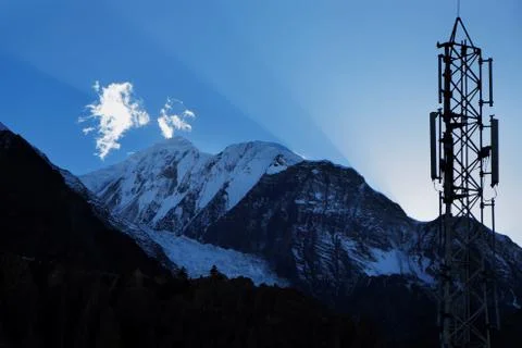 Sun rays and cellular transmitter in the sky over the Himalayas Stock Photos