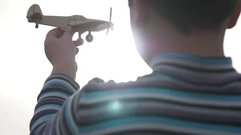 Sun rays and glare on the model airplane in the boy's hand Video stock 88438577