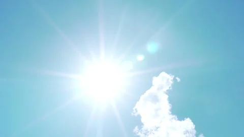 The Sun with Rays and Highlights Close-up and a White Cloud in the Clear Pure Bl Stock Footage 250595741