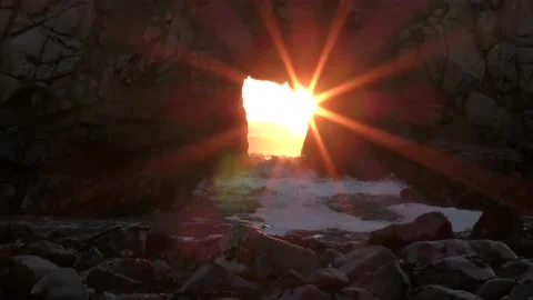 Sun rays beam through keyhole rock sea stack in the ocean Video stock 169404656