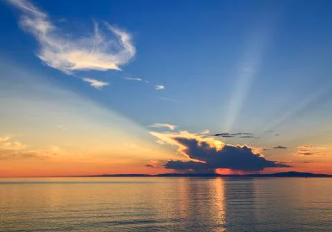 Sun rays from behind clouds at sunset Foto stock