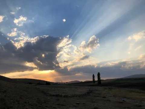 Sun rays behind sunset and clouds Foto stock