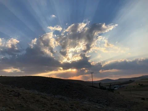 Sun rays behind sunset and clouds Foto stock