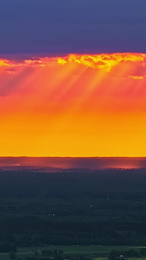 Sun Rays Beneath Dark Clouds Over Countryside at Sunset Stock Footage 342312224