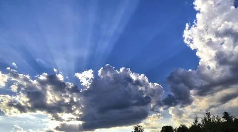 Sun rays with the blue cloudy sky in the background Stock Photos