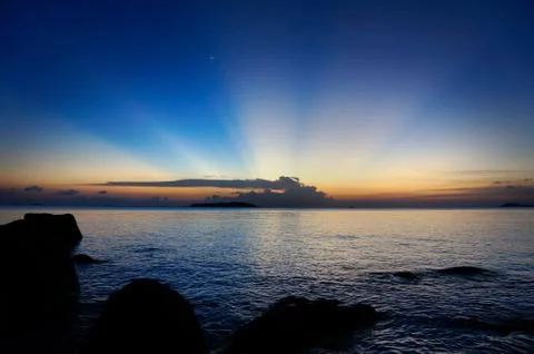 Sun rays in the blue night sky as the sun is setting. Stock Photos