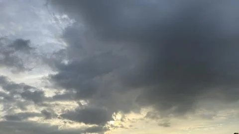 Sun rays break through dramatic dark storm clouds Stock Photos