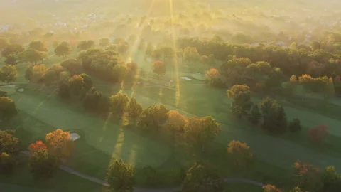 Sun rays break through golden mist above countryside village in autumn forest 4K 스톡 동영상 164113723