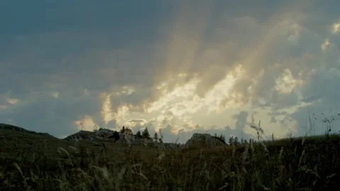 Sun Rays Breaking Through Clouds Over a Grassy Hill Vidéo 284429992