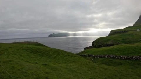 Sun rays breaking through clouds over ocean in Faroe Islands Stock Footage 337558564