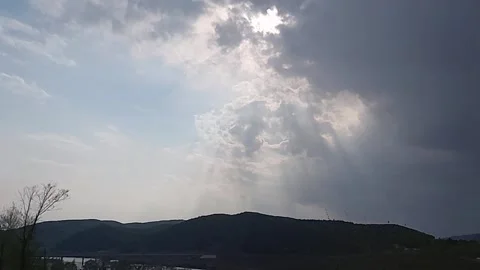 Sun Rays Breaking Through Clouds over Mountains with Bird Flying Stock Footage 340902821