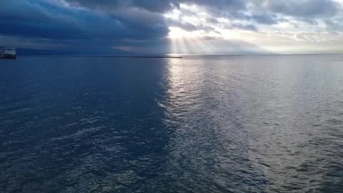 Sun Rays Breaking Through Clouds Over Deep Blue Open Sea Stock Footage 343996806