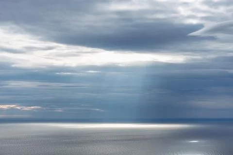Sun rays breaking through the clouds and falling on the Mediterranean Sea Stock Photos