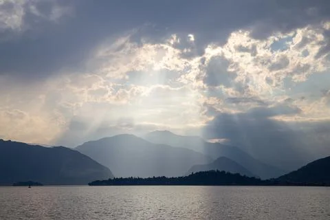 Sun Rays Breaking Through Clouds Above Peaceful Mountain Landscape Stock Photos