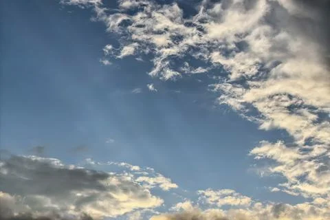 Sun Rays Breaking Through Clouds In Blue Sky Stock Photos