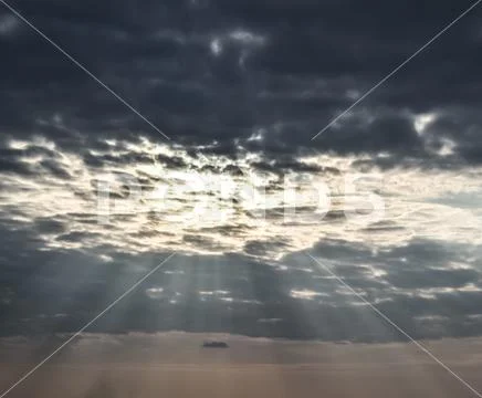Sun rays breaking through cumulus clouds. Heavenly landscape Stock Photos
