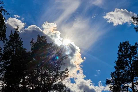 Sun rays breaking through the cumulus clouds Stock Photos