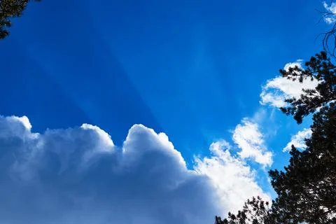 Sun rays breaking through the cumulus clouds Stock Photos