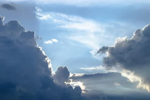 Sun rays breaking through dark clouds at sunset. Stock Photos