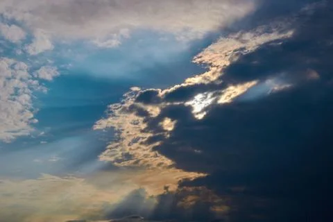 Sun rays breaking through the dark clouds Stock Photos