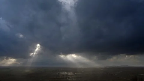 Sun rays breaking through dense storm clouds before and after rain over sky Stock Footage 339398179
