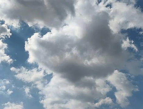 Sun Rays Breaking Through Dramatic Cumulus Clouds in Blue Sky Stock Photos
