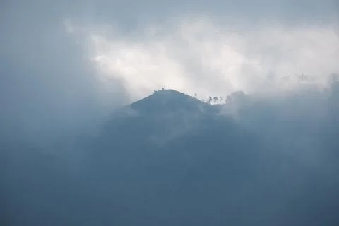 Sun Rays Breaking Through Fog Above Mountain Ridge in Bromo Indonesia 스톡 사진