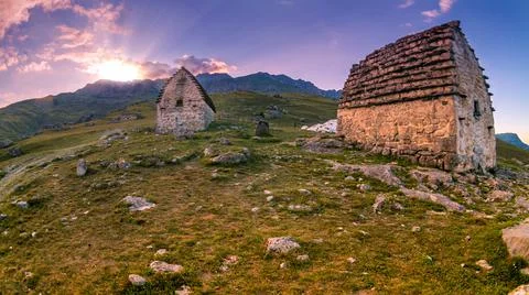 Sun rays breaking through the mountain at sunset. Family crypts on the mountain Fotos de archivo