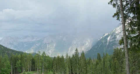 Sun rays breaking through rain over the Dolomites in Italy Stock Footage 340786474