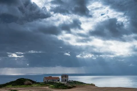 Sun rays breaking through storm clouds above Cabo Espichel coast Stock Photos
