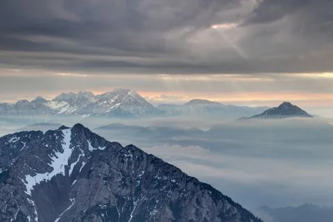 Sun rays burst through dark clouds in Karavanke and Kamnik Alps Stock Photos