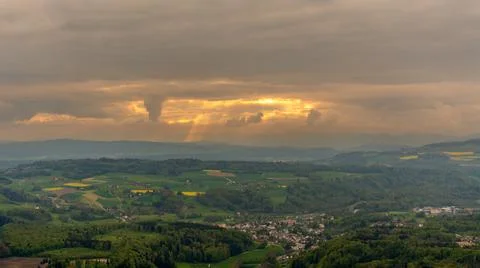 Sun rays bursting through the clouds above the cityscape Stock Photos